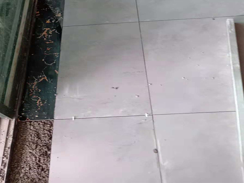 客廳地磚鋪貼：鋪貼的工具包括橡膠錘和粘結(jié)劑。在進(jìn)行施工之前先把所需要的這些材料都整理好放在一旁備用；基層的處理工作對(duì)瓷磚的平整度有很大的影響，對(duì)于基層要做好清潔工作，還有找平工作。放樣：在進(jìn)行瓷磚的鋪貼工作之前還事先找好垂直線，這樣可以在鋪貼的時(shí)候找到瓷磚的水平線，讓瓷磚鋪貼的更加的平整。粘結(jié)劑加水?dāng)嚢杈鶆?，靜置10分鐘之后就可以使用。將瓷磚表面的浮灰清除，再在瓷磚背面均勻的涂抹上粘結(jié)劑，按照預(yù)鋪的順序?qū)⒋纱u鋪貼在地面上，最后用橡膠錘輕輕拍打至服帖齊整。