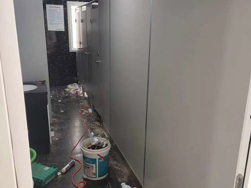 衛(wèi)生間隔斷安裝：在墻壁上找到合適的位置畫出固定片的中心線，看固定板上有幾個固定用的螺絲孔，然后在墻壁中心線上對應的打上幾個孔，把塑膠賽套放入孔內(nèi)，接下來就是用膨脹絲把固定板固定在墻上。固定板和底座的作用就是用來固定隔間板的，把隔間板放在調(diào)整底座上，然后調(diào)整底座高低使隔間板緊貼墻壁上的固定板，然后再微調(diào)底座高低使隔間板距地面有一定距離，大約15厘米就好，然后用水平尺確定水平，等一切都調(diào)整好后，用螺絲把隔間板固定在固定板和調(diào)整底座上。